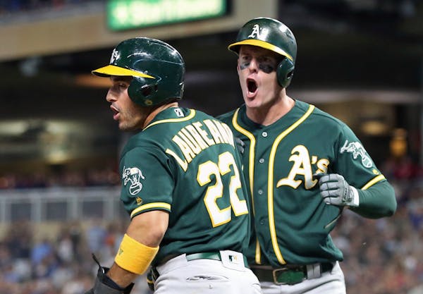 Oakland Athletics' Ramon Laureano, left, and Mark Canha celebrate after they scored on a two-run double by Chris Davis off Minnesota Twins relief pitc