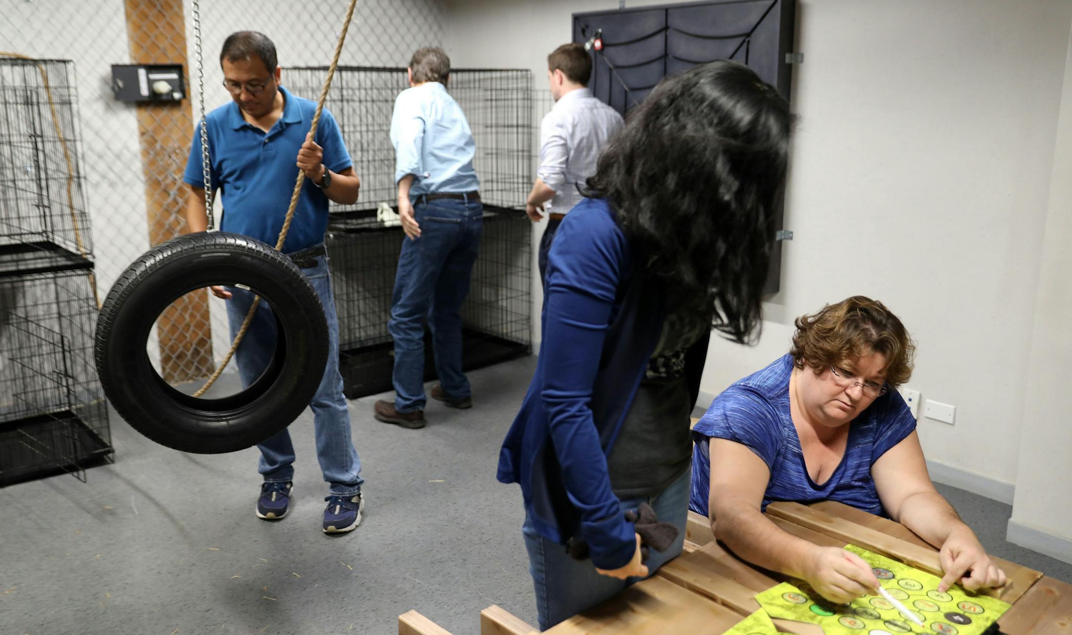 United Airlines employees, including Lizzie Cristobal, standing right, and Rhonda Crenshaw, seated right, take part in a corporate team building exercise, working together to free themselves from an "escape room" at PanIQ Escape Room Chicago on Thursday, June 29, 2017 in Chicago, Ill. (Terrence Antonio James/Chicago Tribune/TNS)
