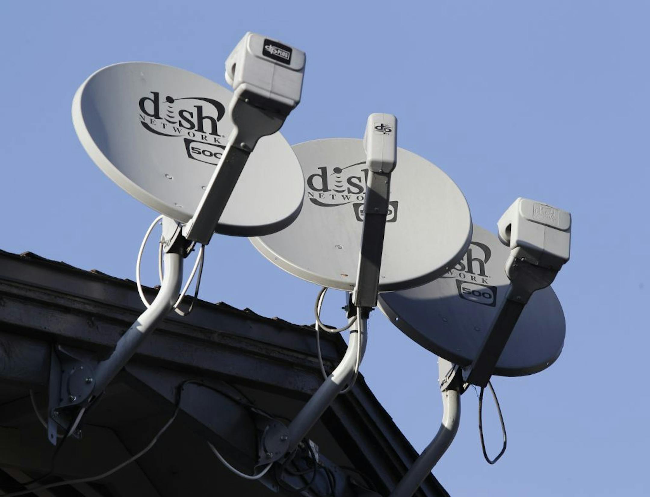 FILE - Three Dish Network satellite dishes are shown at an apartment complex in Palo Alto, Calif., in this Feb. 23, 2011 file photo.