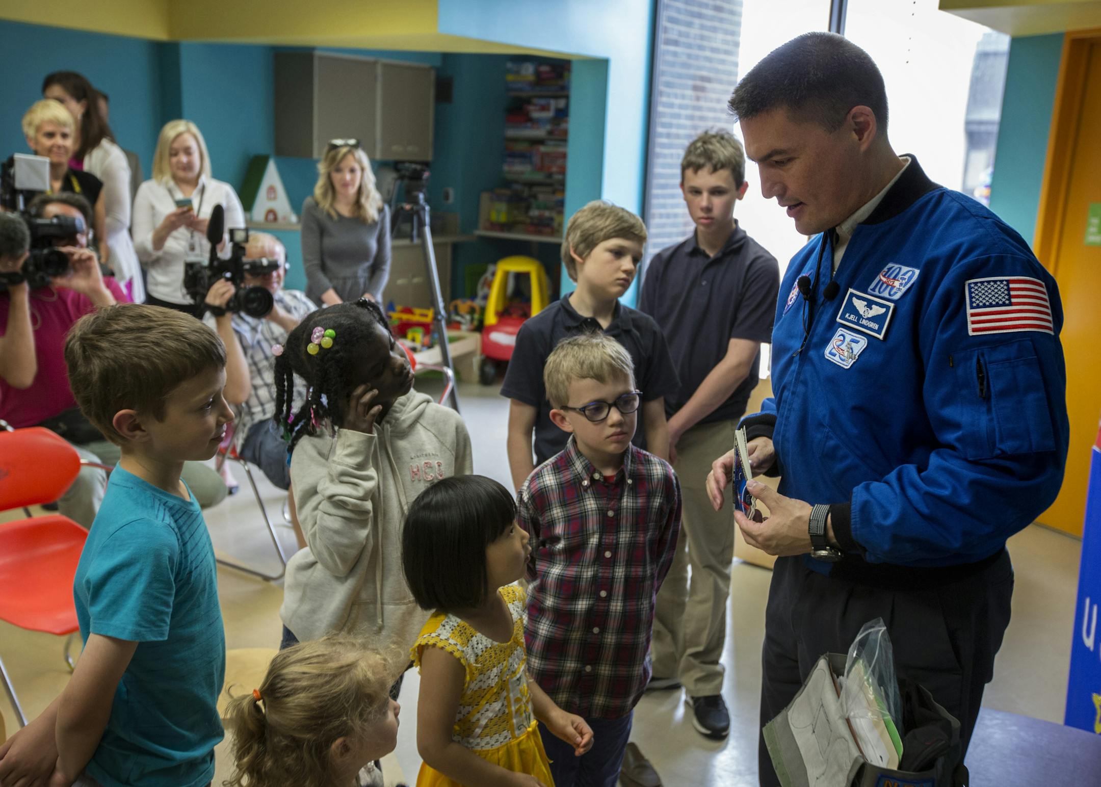 Dr. Kjell Lindgren has returned to Earth from a mission on the International Space Station, and Wednesday he visited HCMC in Minneapolis, where he was a doctor, and read the book Moustronaut, (Written by former NASA shuttle commander Mark Kelly.) to pediatric patients. After reading the book and answering the children's questions, Lindgren handed out stickers from his Space Station Mission. ] Minneapolis, MN - 05/25/2016