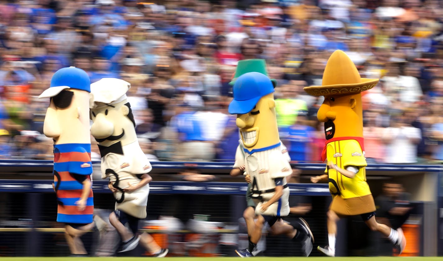 FILE - In this July 13, 2019, file photo, fans watch the racing sausages during a baseball game between the Milwaukee Brewers and the San Francisco Giants in Milwaukee. The chairman of the Wisconsin Republican Party, Andrew Hitt, is warning Milwaukee's chief elections official that it would be illegal for any Milwaukee Bucks or Brewers players or mascots to participate in early voting events planned at their stadiums in the days leading up to the election. Milwaukee plans to allow for in-person absentee voting at Miller Park and Fiserv Forum between Oct. 20 and Nov. 1. (AP Photo/Morry Gash, File)