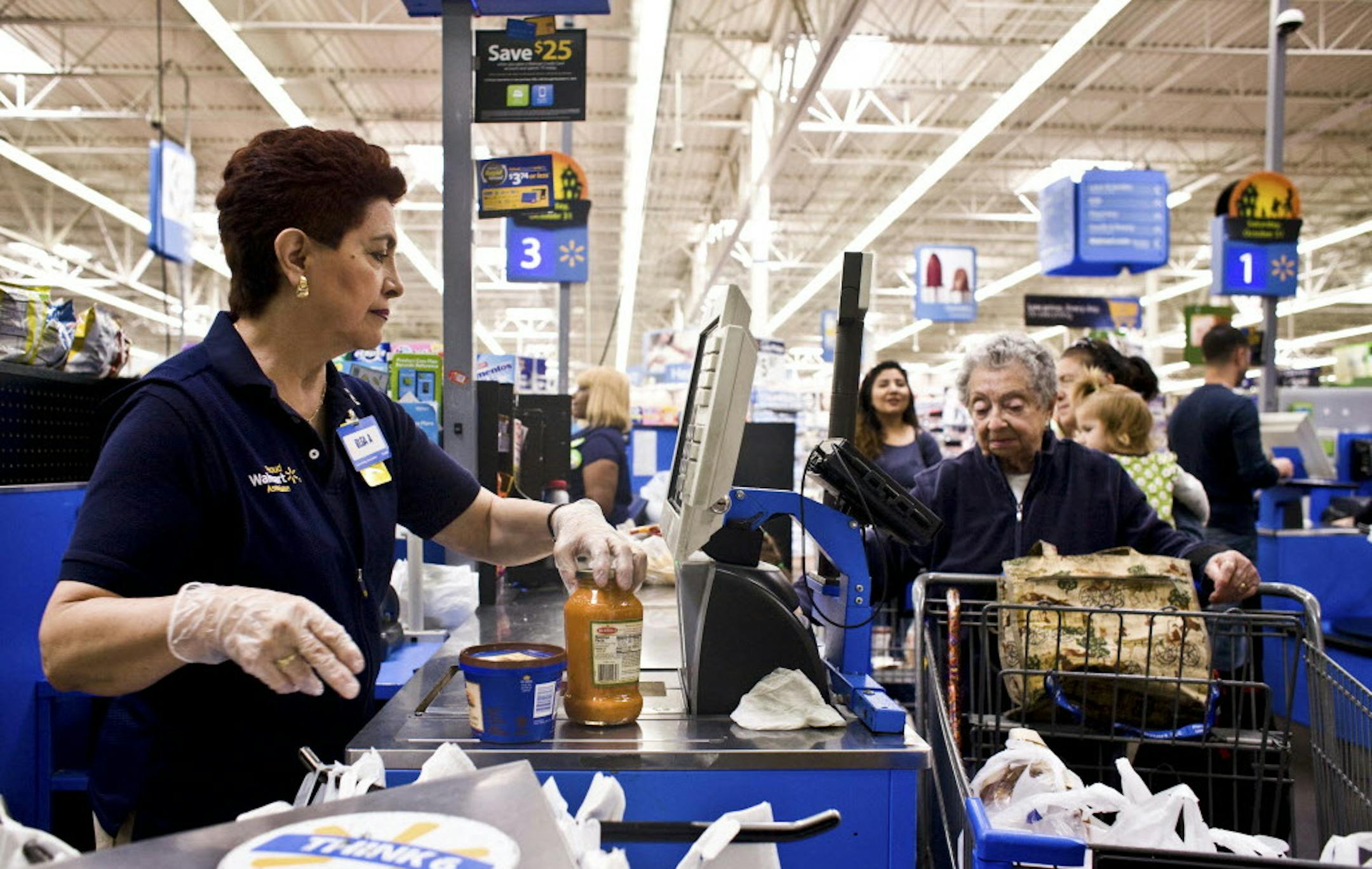 FILE ó Olga Aguirre checks out a customer at a Walmart Supercenter in North Bergen, N.J., Sept. 23, 2015. When Walmart announced in October that it was significantly increasing its investment in e-commerce, it tacitly acknowledged that it had fallen far behind Amazon in the race for online customers. (Bryan Anselm/The New York Times)
