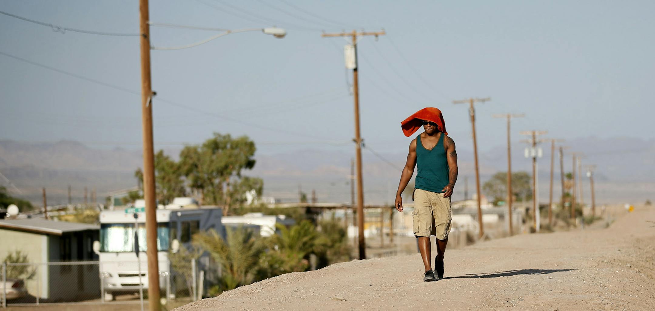 Cedric Thompson wore a towel to protect him self from the hot sun as he walked through Bombay Beach on a recent visit . Thompson grew up in Compton. His freshman year at Piedmont High School, three people close to him (a cousin and two friends) were killed in gang shootings. His parents divorced, and his mother urged him to get out of L.A., and move with his dad in Bombay Beach, a forgotten outpost on the Salton Sea. ] JERRY HOLT ‚Ä¢ jerry.holt@startribune.com