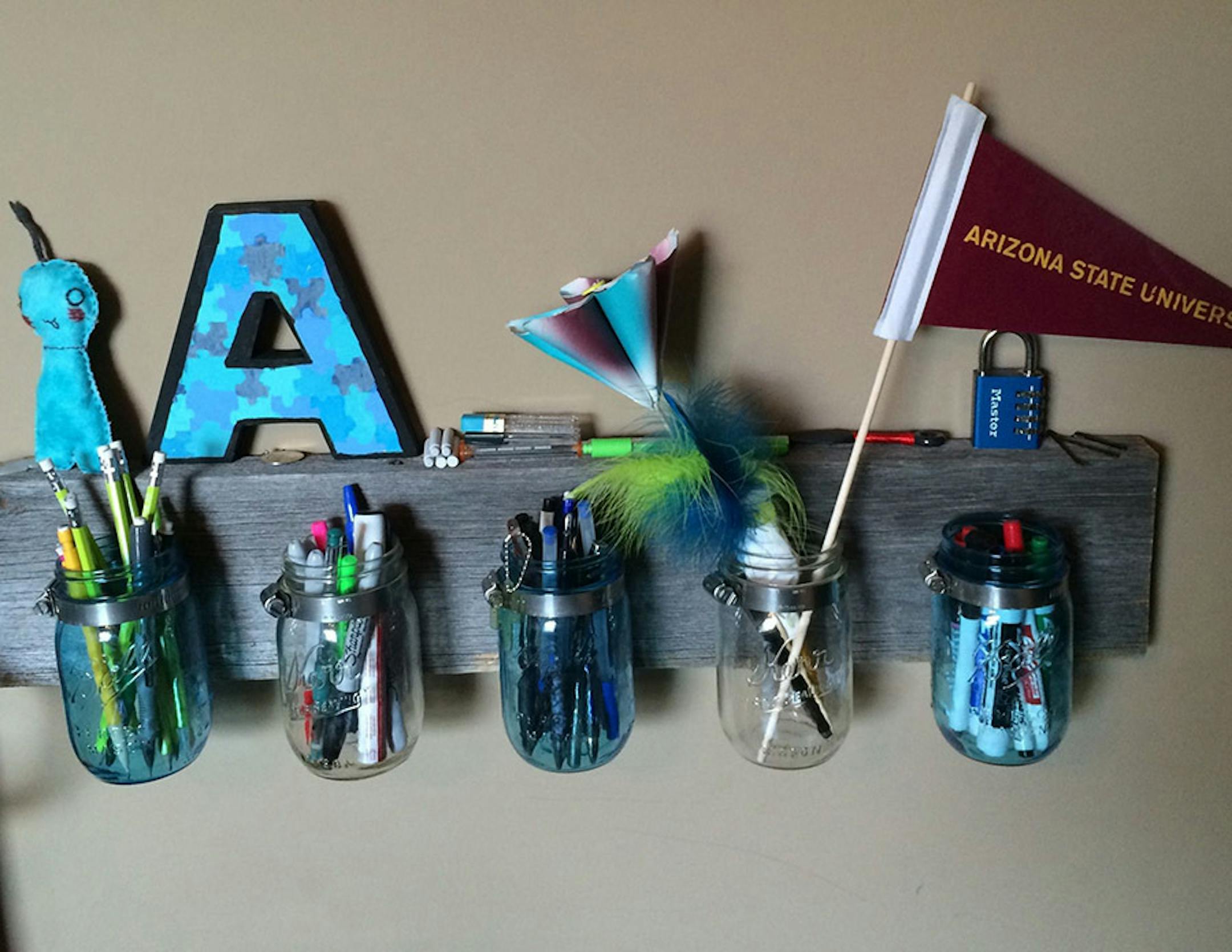 Abigail used old wood and Mason jars to craft this wall storage for pens and pencils.