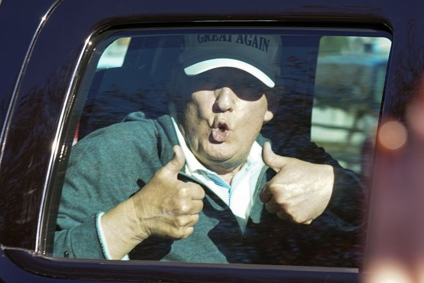 President Donald Trump gives two thumbs up to supporters as he departs after playing golf at the Trump National Golf Club in Sterling Va., Sunday Nov. 8, 2020.