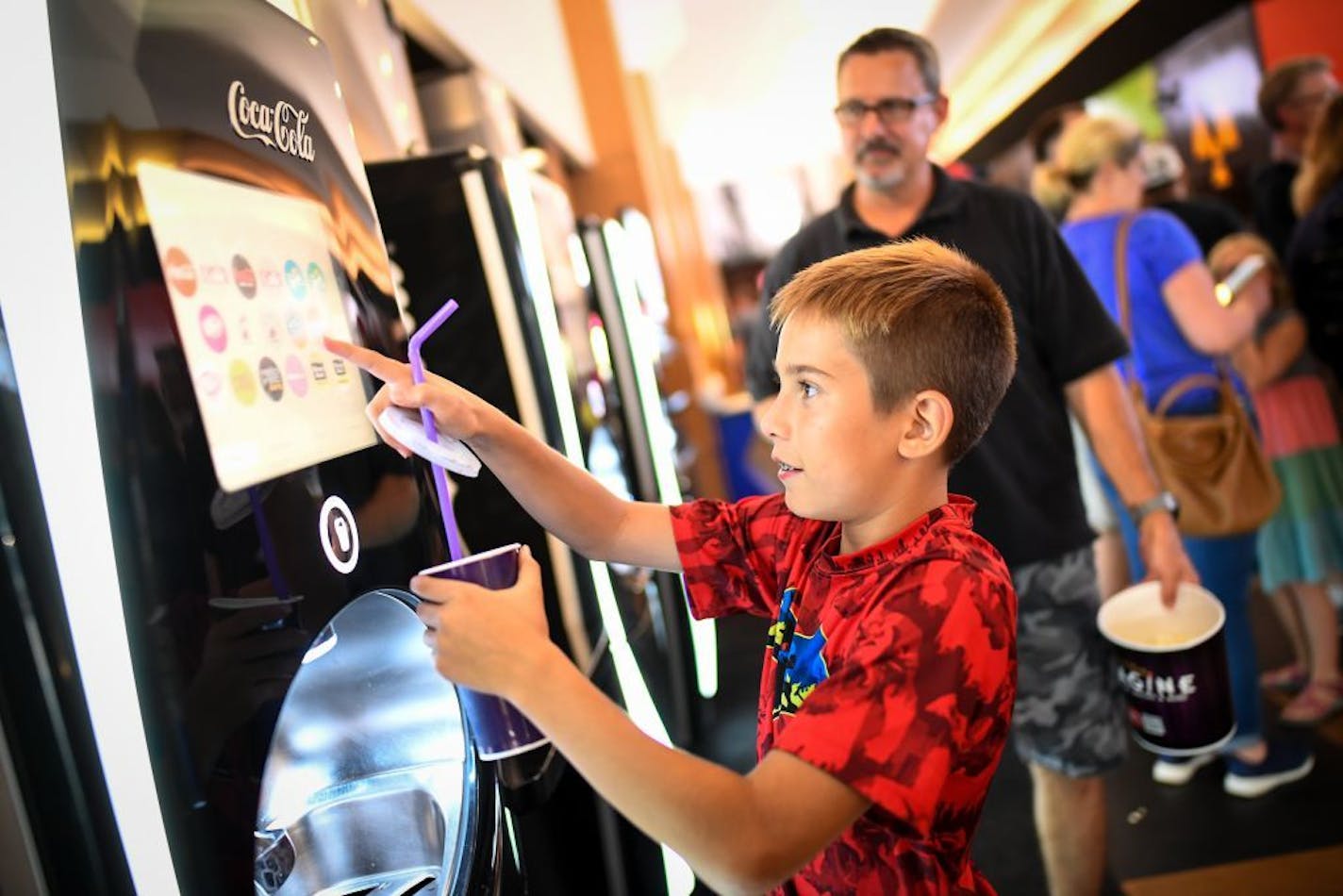 Shawn Crandall watched his son, Slater, 13, make a drink for himself from one of Emagine Willow Creek's customized, self-serve soda machines. They were waiting to see Jurassic World: Fallen Kingdom Tuesday evening.