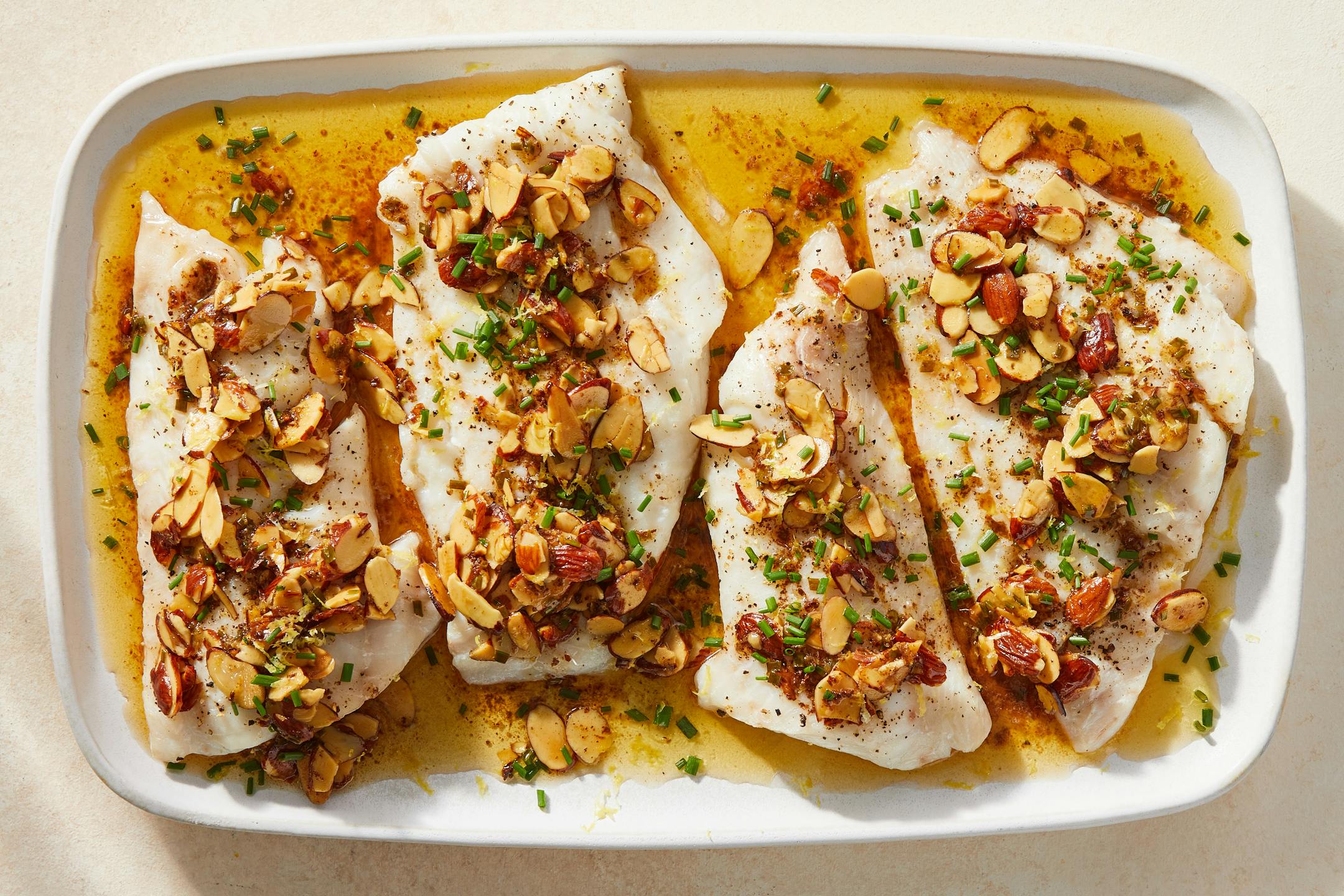 Fish almondine, a nutty variation on a French classic, sole meuniere, in New York, Feb. 16, 2023. Any fish works, particularly lean flaky fillets, for this roasted dish, which is weeknight easy and Julia Child fancy. Food Stylist: Barrett Washburne. (Julia Gartland/The New York Times)