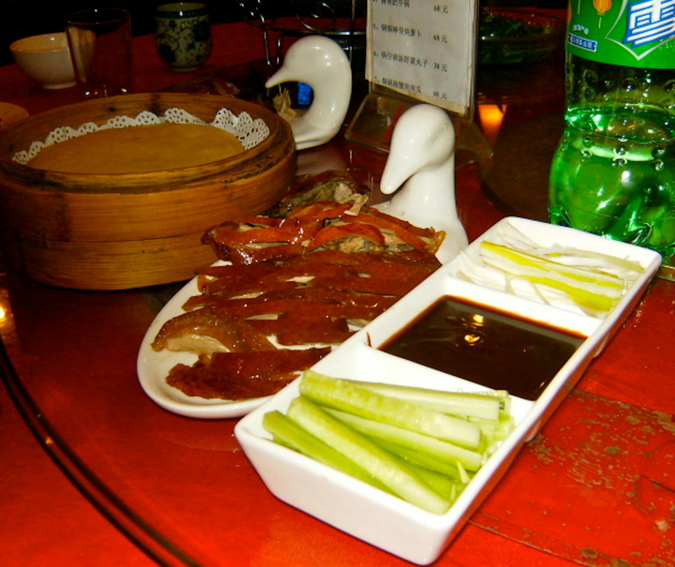 The duck meat is served on the plate with the duck head. Cute, huh?