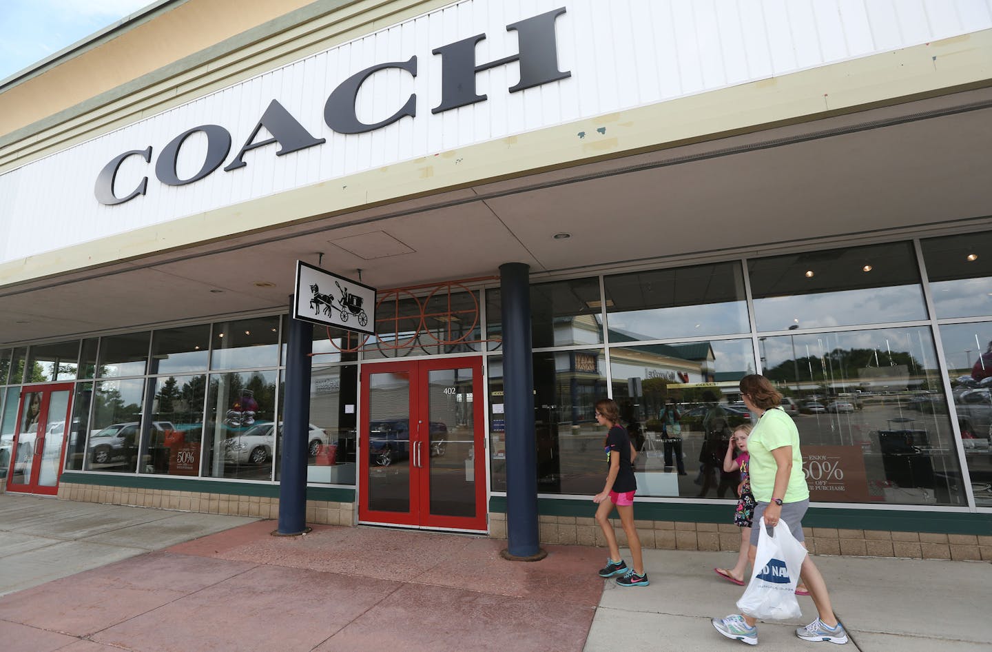 Patrons head toward the New Coach store at the Medford Outlet Center. ] (KYNDELL HARKNESS/STAR TRIBUNE) kyndell.harkness@startribune.com At the Medford Outlet Center in Medford, Min. Tuesday, August, 5, 2014.