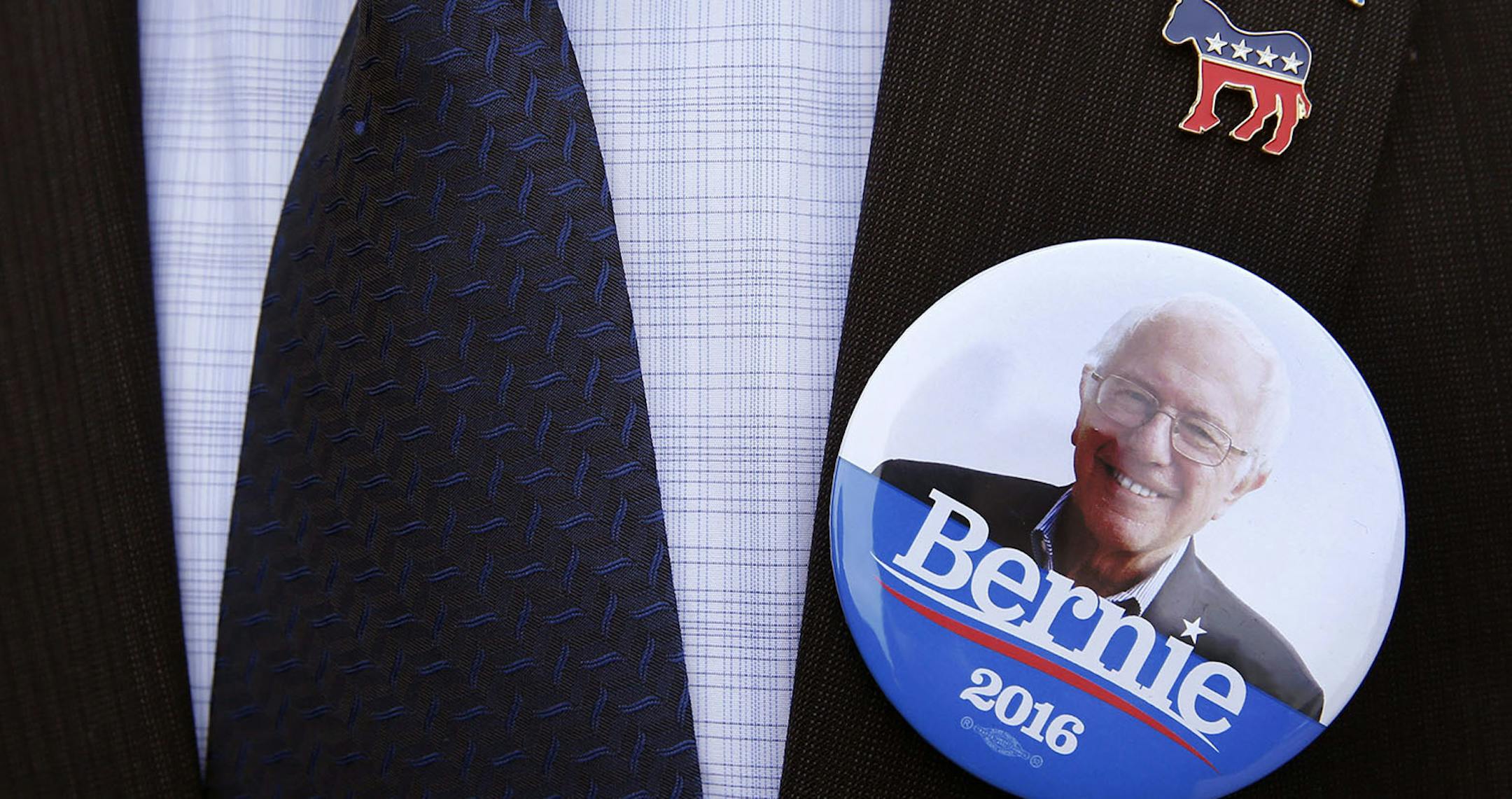 Julio Salazar, from Morristown, Tenn., a supporter of Democratic presidential candidate, Sen. Bernie Sanders, I-Vt, wears a suit coat and tie with a Sanders button as he waits in line outside a campaign event Sunday, May 1, 2016, in South Bend, Ind. (AP Photo/Charles Rex Arbogast) ORG XMIT: MIN2016050313191453