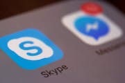 This Saturday, April 9, 2016 photo shows the icons for Microsoft's Skype and Facebook's Messenger apps on a smartphone in New York. In coming months, 