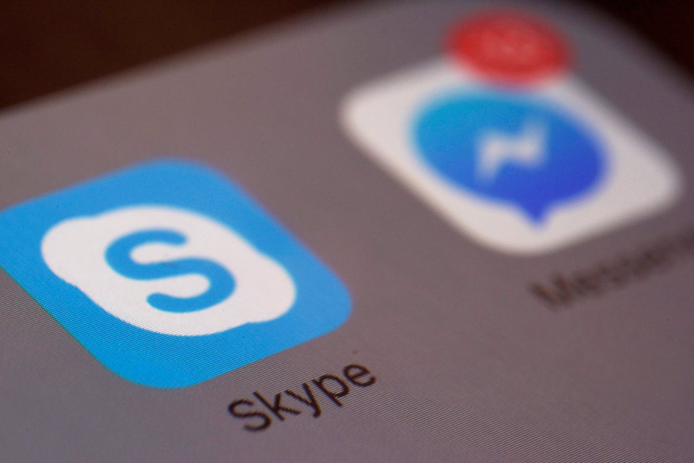 This Saturday, April 9, 2016 photo shows the icons for Microsoft's Skype and Facebook's Messenger apps on a smartphone in New York. In coming months, people who use Messenger, Skype and Canada's Kik for online chats can expect to see all kinds of businesses offering information and other services with the help of messaging "bots," or software that�s capable of human-like conversation. (AP Photo/Patrick Sison)