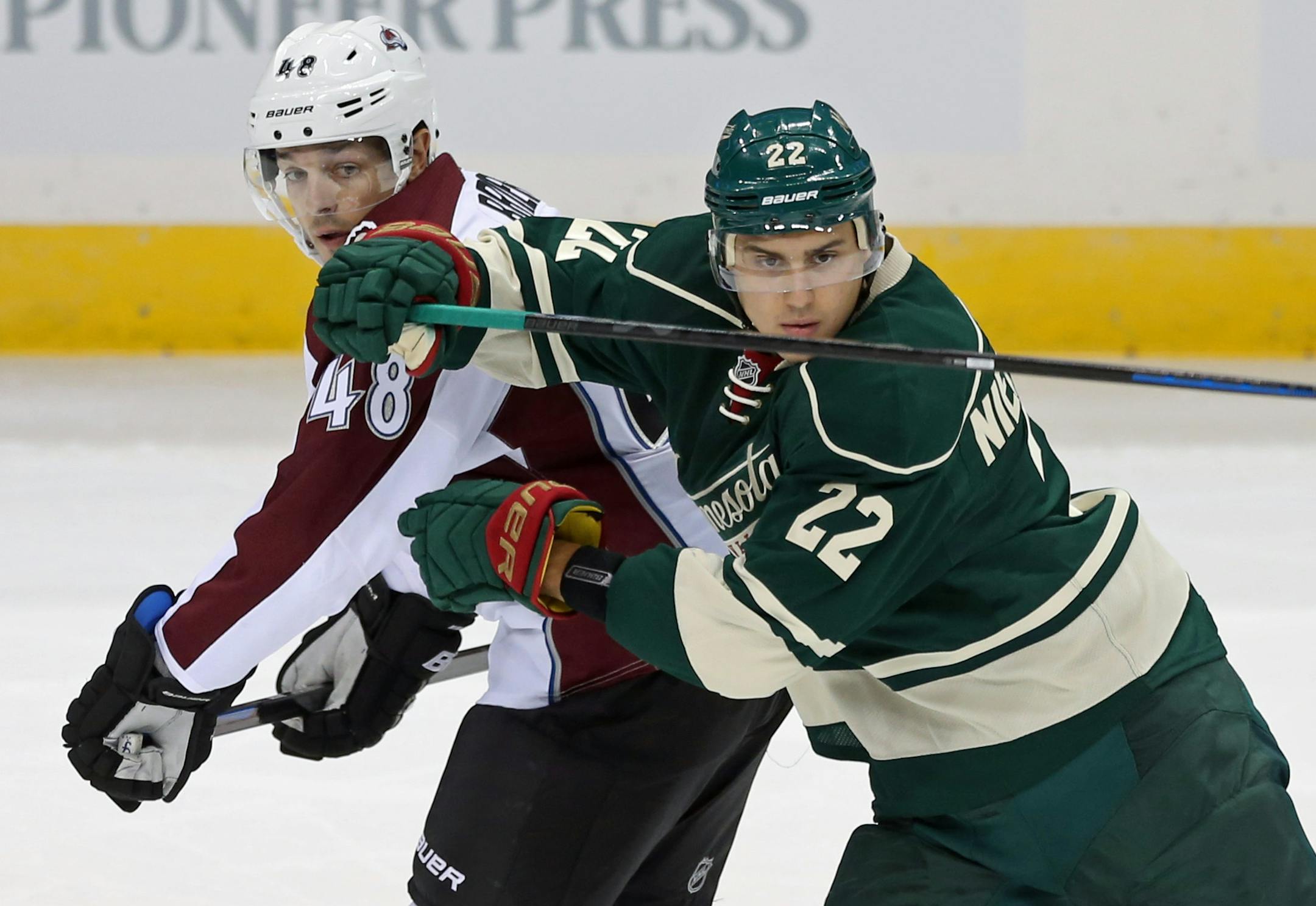 Minnesota Wild's Nino Niederreiter, right, of Switzerland, eyes the puck as he tries to keep Colorado Avalanche' s Daniel Briere at bay in the first period of an NHL hockey game, Thursday, Oct. 9, 2014, in St. Paul, Minn. (AP Photo/Jim Mone)