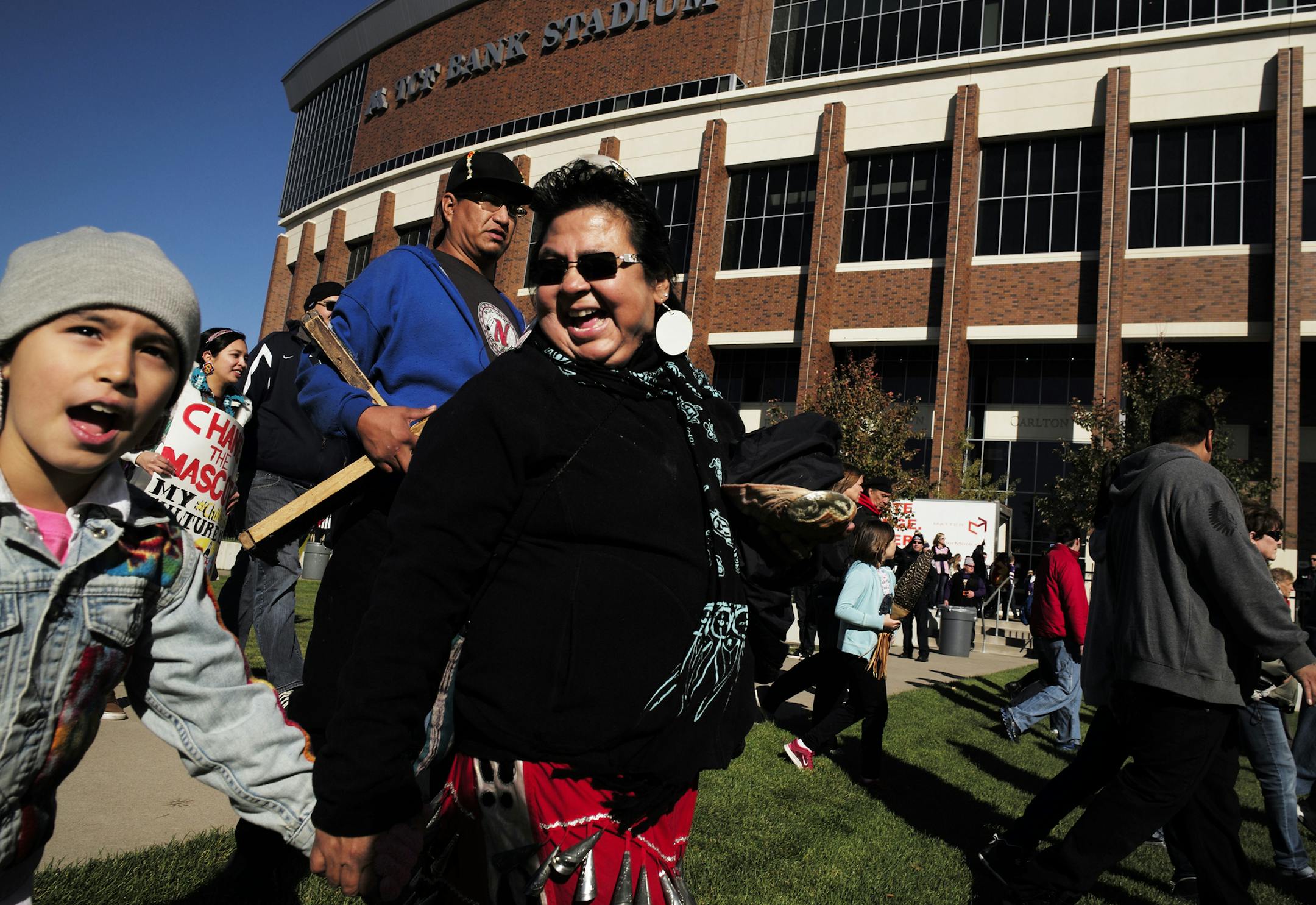 Bestie Bissonette, 8, and her grandmother Lisa Belanger chanted "no more mascots" as they arrived at TCF Bank Stadium in Minneapolis to participate in the No Honor in Racism rally on Sunday.