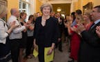 Staff clap as new Prime Minister Theresa May, followed by her husband Philip John, arrives at 10 Downing Street in London after meeting Queen Elizabet