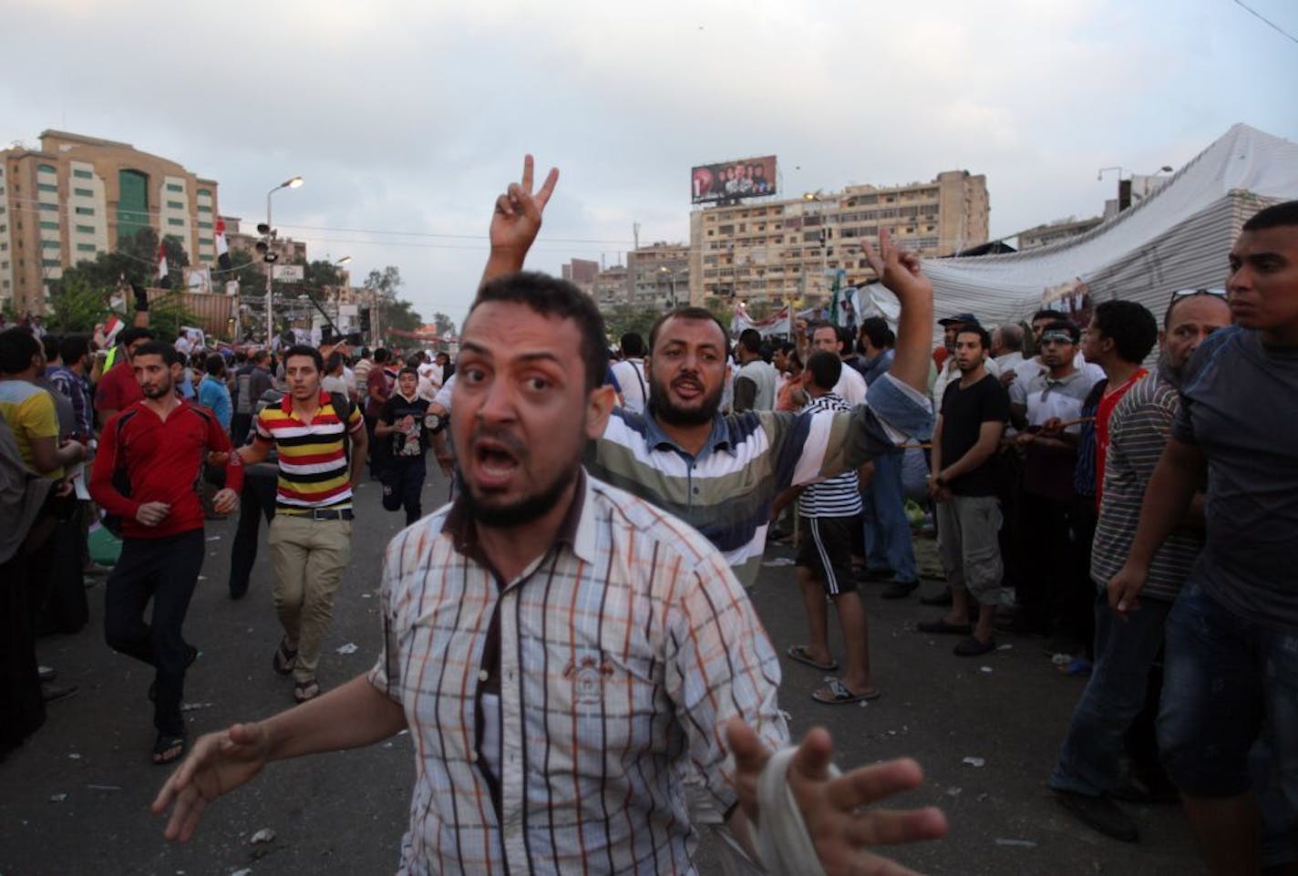 Supporters of Egypt's ousted President Mohammed Morsi gather outside a field hospital following clashes with security forces at Nasr City, where pro-Morsi protesters have held a weeks-long sit-in, in Cairo, Egypt, Saturday, July 27, 2013. Police fired tear gas to disperse hundreds of Morsi supporters, setting off clashes that lasted for hours and left tens of people dead.