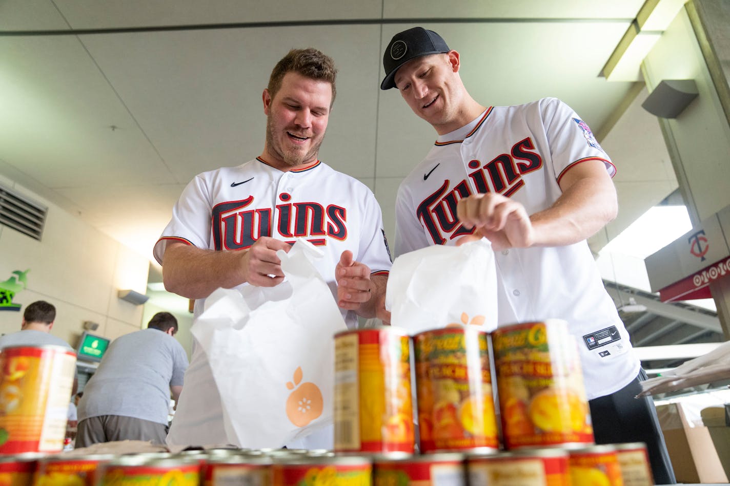 Minnesota Twins pitchers Dylan Bundy and Nick Gordon, left to right, pack non-perishable food Wednesday, May 11, 2022 at Target Field in Minneapolis, Minn. The food will be donated to Every Meal to help feed Minnesota children living with food insecurity. ]