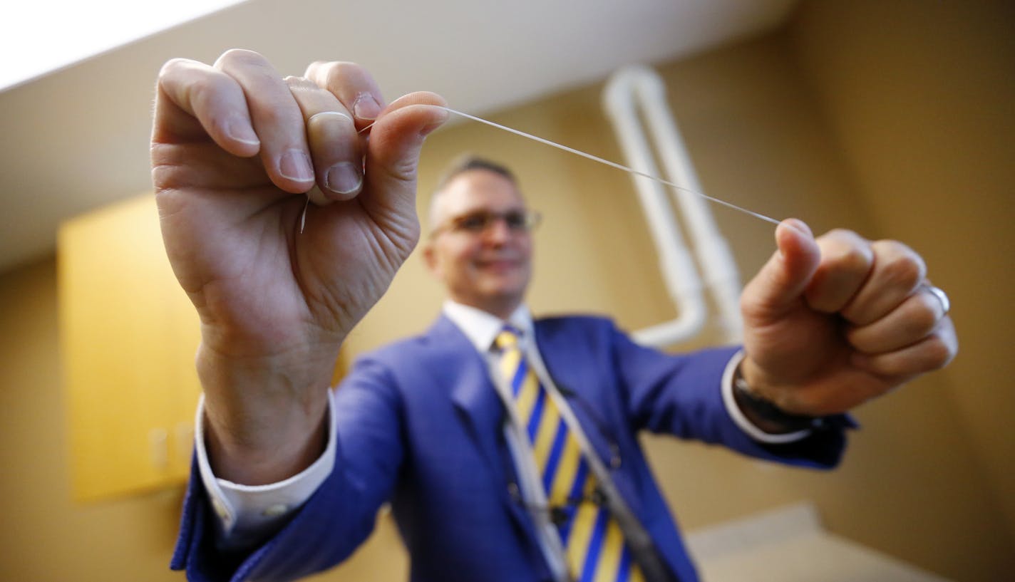 Dr. Wayne Aldredge, president of the American Academy of Periodontology, holds a piece of dental floss at his office in Holmdel, N.J. Aldredge acknowledges the weak scientific evidence and the brief duration of many studies on flossing, but says that the impact of floss might be clearer if researchers focused on patients at the highest risk of gum disease, such as diabetics and smokers. (AP Photo/Julio Cortez)