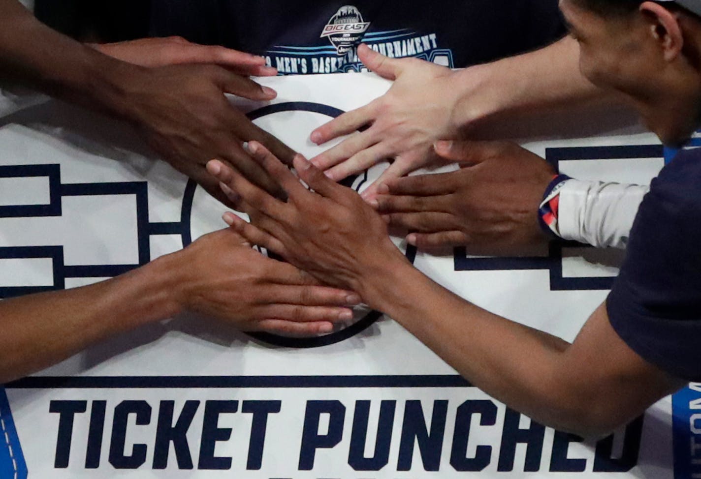 Villanova players stick a logo of their team on a bracket board after defeating Seton Hall 74-72 in the championship of the Big East Conference tournament