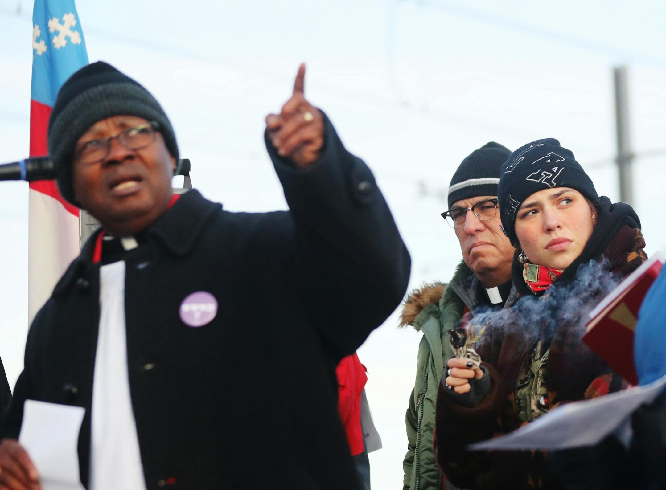 Rev. James Wilson of Holy Trinity Episcopal Church in St. Paul, points to the Whipple Federal Building as Reed Two Bulls of South Minneapolis burns sage Tuesday, Oct. 29, 2019, in St. Paul, MN. Clergy and protestors gathered for a service and communion outside the Whipple Federal Building and to protest the naming of the building after the Episcopal bishop because deportations and other actions at the courthouse are in opposition to the beliefs of the Episcopal church, they stated.