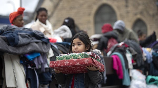 Briella Jones 5, who lived in the Francis Drake Hotel apartments with her family, holds donated Christmas presents on Wednesday, Dec. 25, 2019, in Min