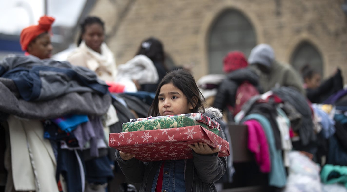 Briella Jones 5, who lived in the Francis Drake Hotel apartments with her family, holds donated Christmas presents on Wednesday, Dec. 25, 2019, in Mineeapolis. Hundreds of people were left in the cold early Christmas morning after a four-alarm blaze at the complex.