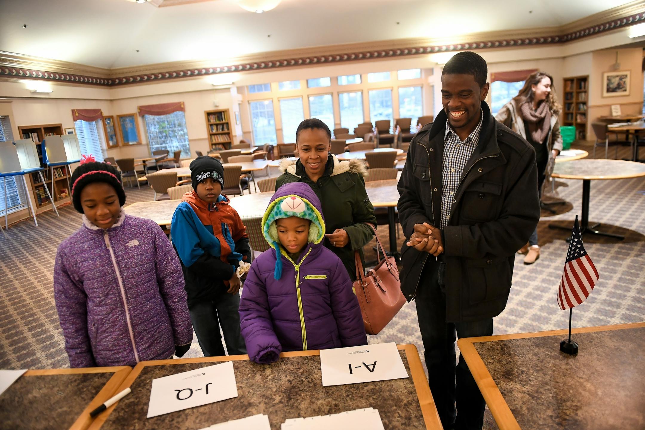 St. Paul mayoral candidate Melvin Carter, his wife, Sakeena, and their three children, Maylena, 11, Myles, 10, and Naomi, 9, walked up a registration table at Ravoux Hi-Rise before casting their votes Tuesday morning in the St. Paul mayoral election.