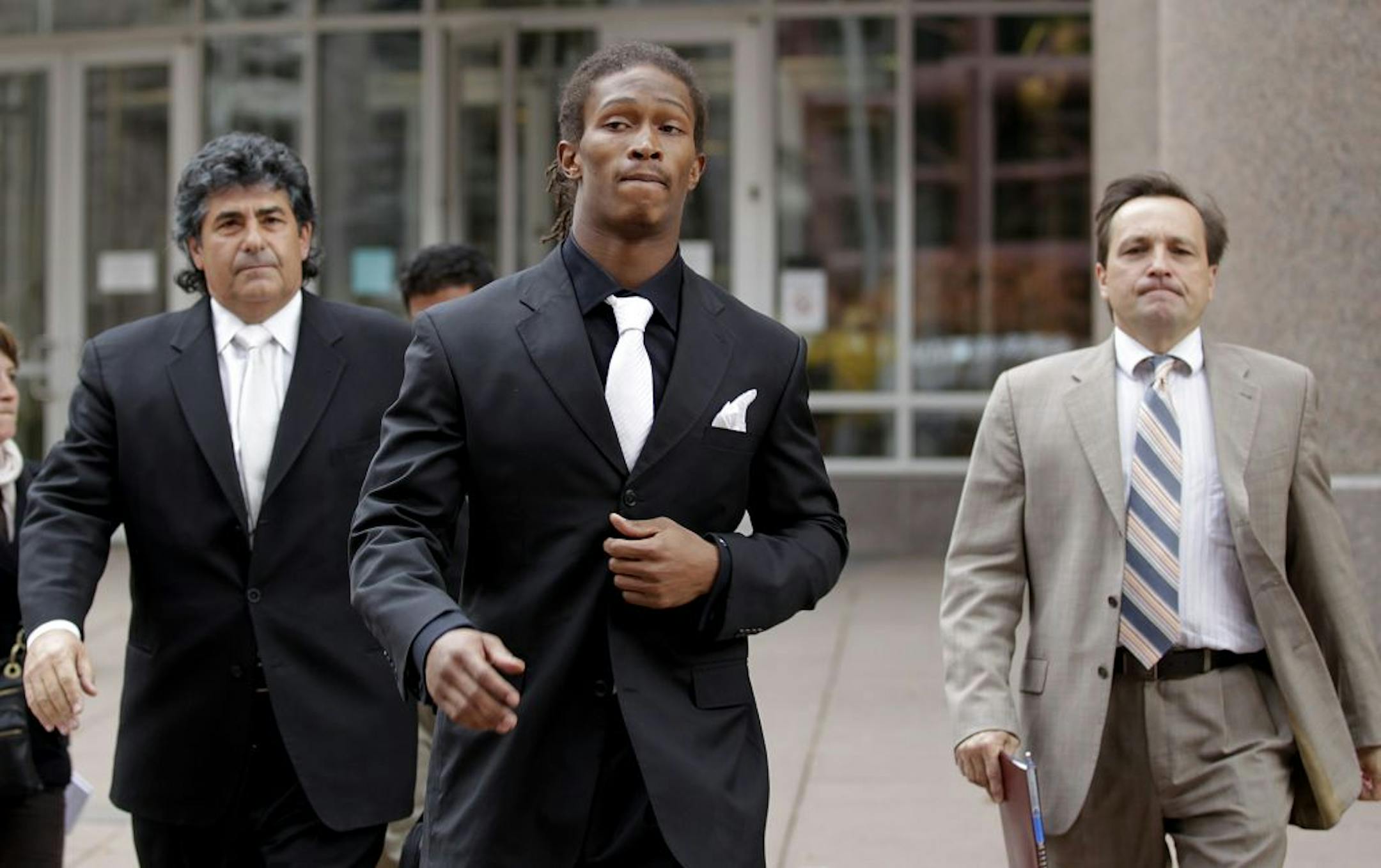 Minnesota Vikings Chris Cook flanked by his attorneys walked out of the Public Safety Facility Wednesday October, 26, 2011 in downtown Minneapolis, MN. after his court hearing. Cook was charged with felony domestic assault .