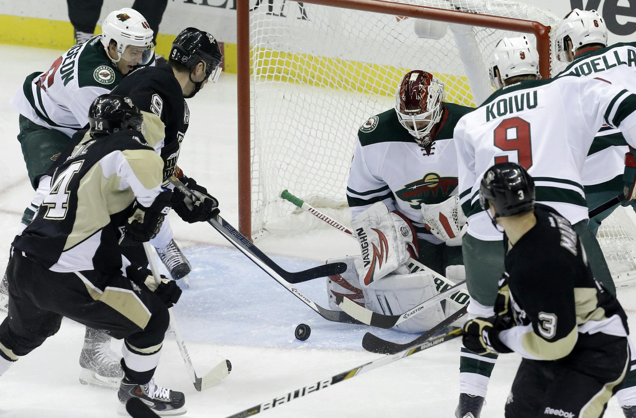 Pittsburgh Penguins' Pascal Dupuis (9) gets to a rebound off Minnesota Wild goalie Niklas Backstrom (32) and gets it past Backstrom for a goal in the first period of an NHL hockey game in Pittsburgh, Thursday, Dec. 19, 2013. (AP Photo/Gene J. Puskar)
