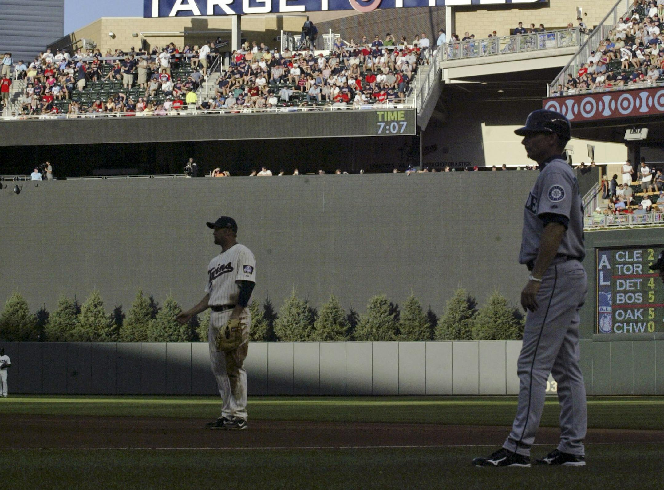 FILE- In this July 31, 2010, file photo, the center field sign Target Field featuring the Minnie and Paul logo looms over the field during a baseball game between the Minnesota Twins and the Seattle Mariners in Minneapolis. The Twins said they will take down the pine trees behind center field wall after hitters complained they made it difficult for them to pick up the ball out of the pitcher's hand. (AP Photo/Paul Battaglia, File)