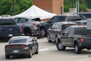 An investigator goes through the scene of crash believed to be part of a fatal shooting by a federal task force on the top of a parking ramp in Minnea