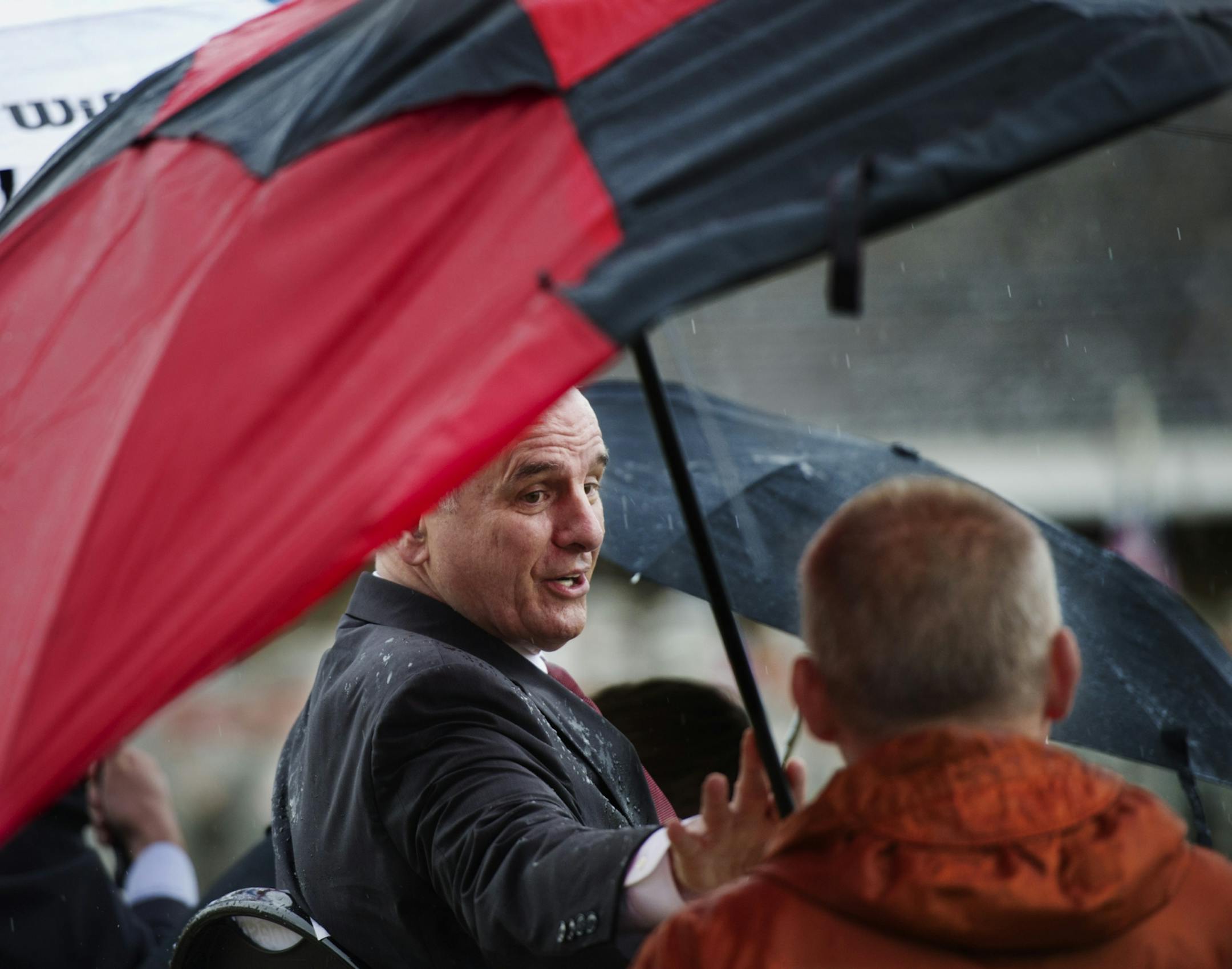 Minnesota Gov. Mark Dayton declined several offers for umbrellas while on stage with other dignitaries during the deployment ceremony Sunday for the 1st Brigade Combat Team, 34th Red Bull Infantry Division.