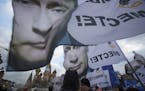 People rally in support of Crimea joining Russia, with banners and portraits of Russian President Vladimir Putin, reading "We are together," in Red Sq