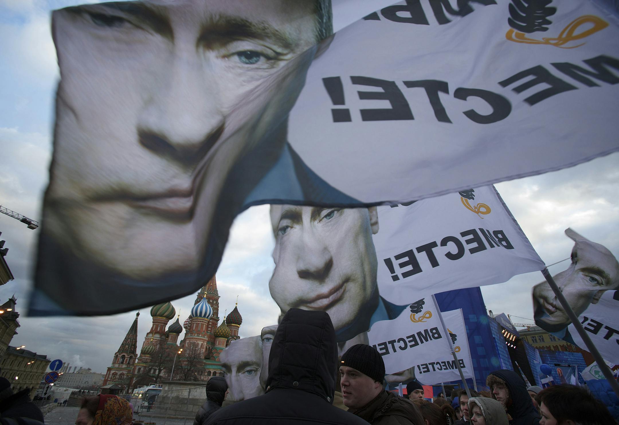 People rally in support of Crimea joining Russia, with banners and portraits of Russian President Vladimir Putin, reading "We are together," in Red Square in Moscow, Tuesday, March 18, 2014. With a sweep of his pen, President Vladimir Putin added Crimea to the map of Russia on Tuesday, describing the move as correcting past injustice and responding to what he called Western encroachment upon Russia's vital interests. (AP Photo/Pavel Golovkin) ORG XMIT: MOSB155