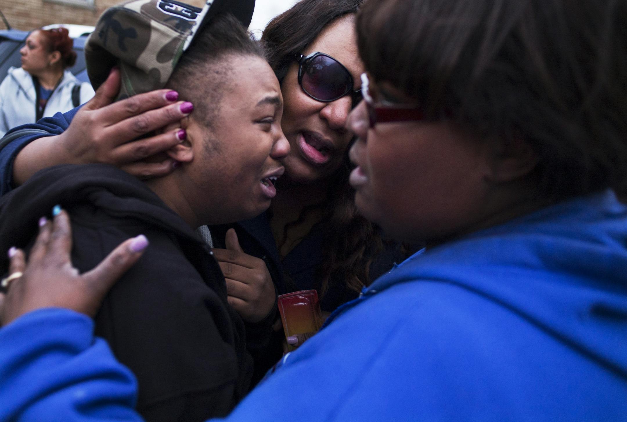 In front of the apartment where Samirria White was killed by her boyfriend, friends and relatives paid homage to the young mother with a candlelight vigil. Grieving older sister Sasha Cummings was comforted by cousins KaRynn Cummings and Tawanda Johnson, right.