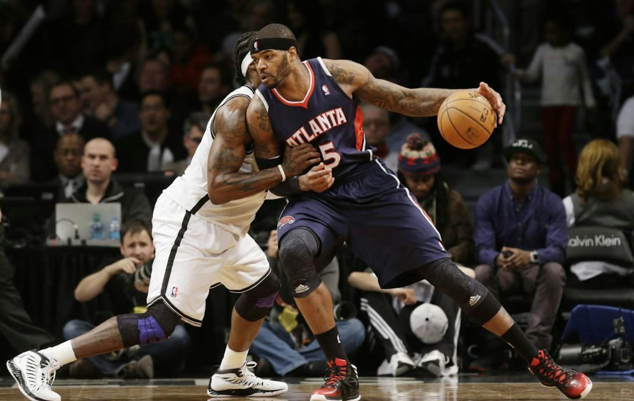 Brooklyn Nets forward Gerald Wallace, left, defends against Atlanta Hawks forward Josh Smith (5) in the first half of their NBA basketball game at the Barclays Center, Friday, Jan. 18, 2013, in New York.