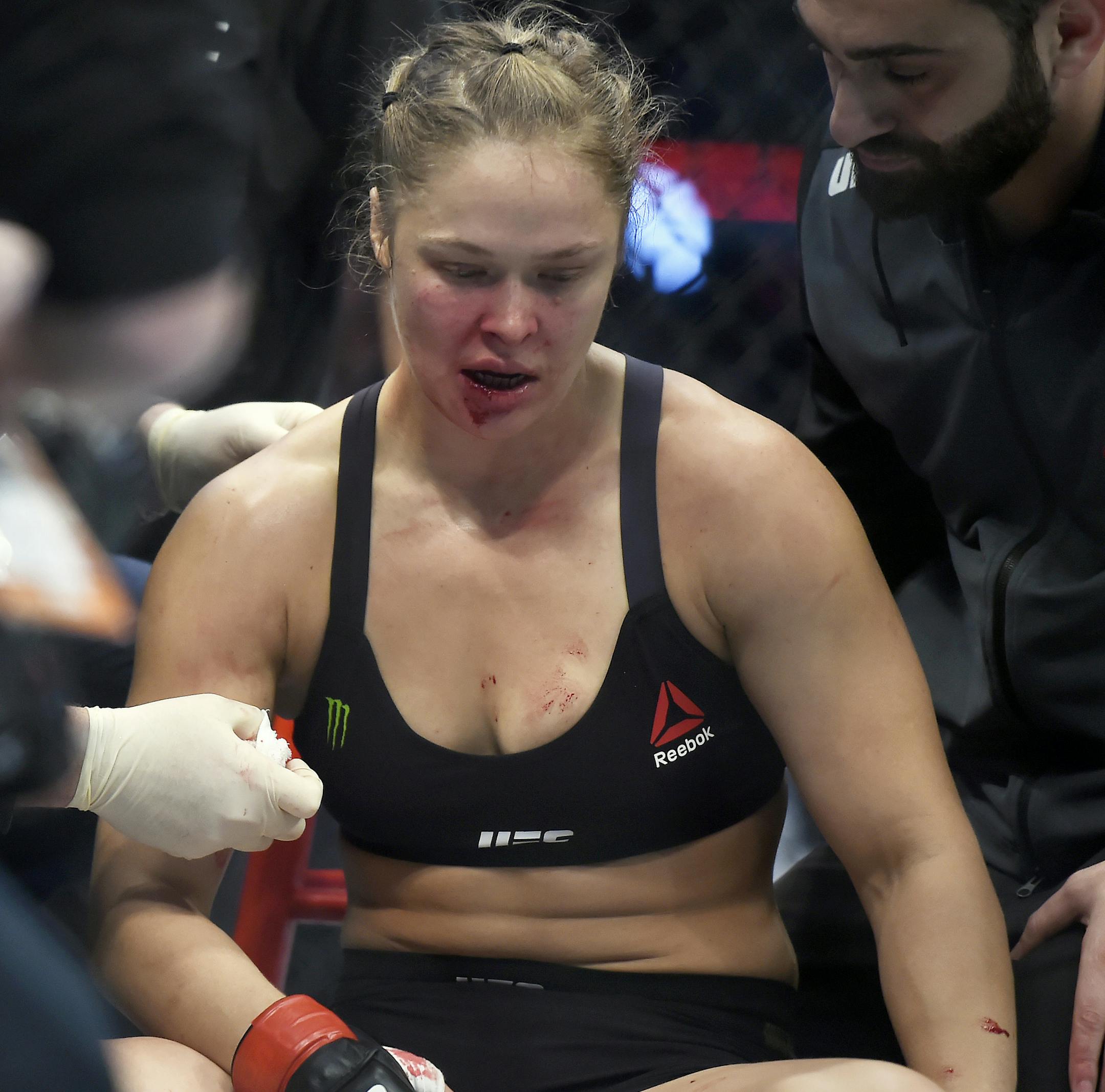 Ronda Rousey is treated by a medical staff member after being knocked out by Holly Holm in their UFC 193 bantamweight title fight in Melbourne, Australia, Sunday, Nov. 15, 2015. Holm pulled off a stunning upset victory over Rousey in the fight, knocking out the women's bantamweight champion in the second round with a powerful kick to the head Sunday. (AP Photo/Andy Brownbill)