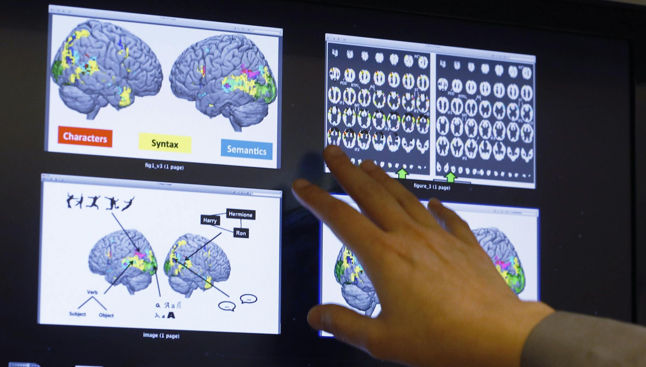 Leila Wehbe, a Ph.D. student at Carnegie Mellon University in Pittsburgh, displays images that used brain scans made from volunteers in a recent experiment while in her office on Wednesday Nov. 26, 2014. Images show a combination of data and graphics compiled as each word of a chapter of "Harry Potter and the Sorcerer's Stone" was flashed for half a second onto a screen inside a brain-scanning MRI machine. (AP Photo/Keith Srakocic)