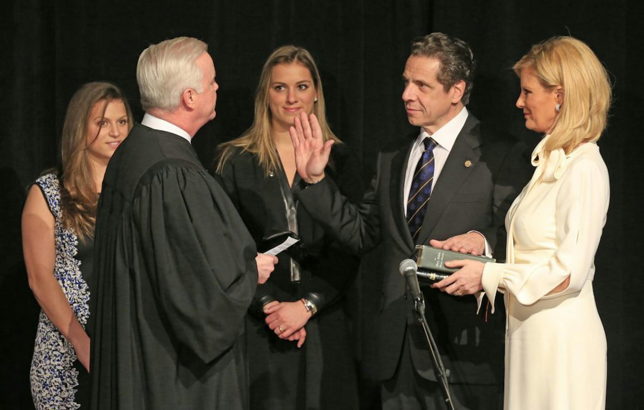 New York Gov. Andrew Cuomo is sworn in at the Buffalo and Erie County Historical Society in Buffalo, N.Y., by the Gerald Whalen, joined by his daughters Cara, left, and Mariah, as his partner, Sandra Lee, holds the Bible on Thursday, Jan. 1, 2015. Cuomo was inaugurated for a second term earlier Thursday at One World Trade Center.