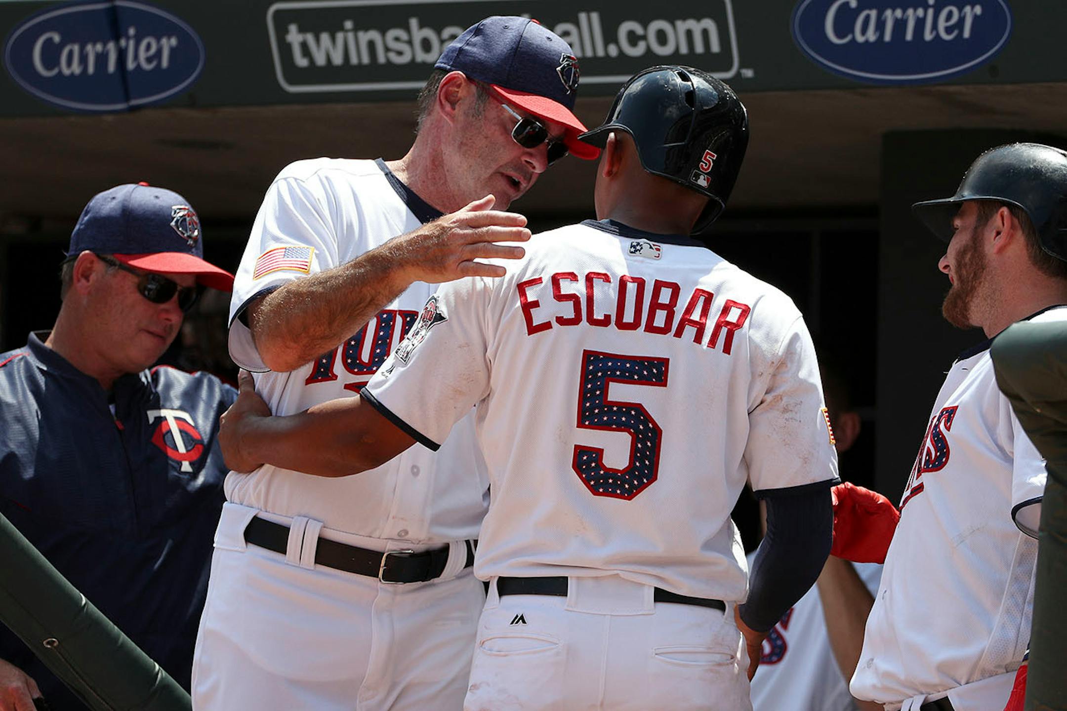 Minnesota Twins third baseman Eduardo Escobar (5) was congratulated by Minnesota Twins manager Paul Molitor (4) after scoring in the second inning.