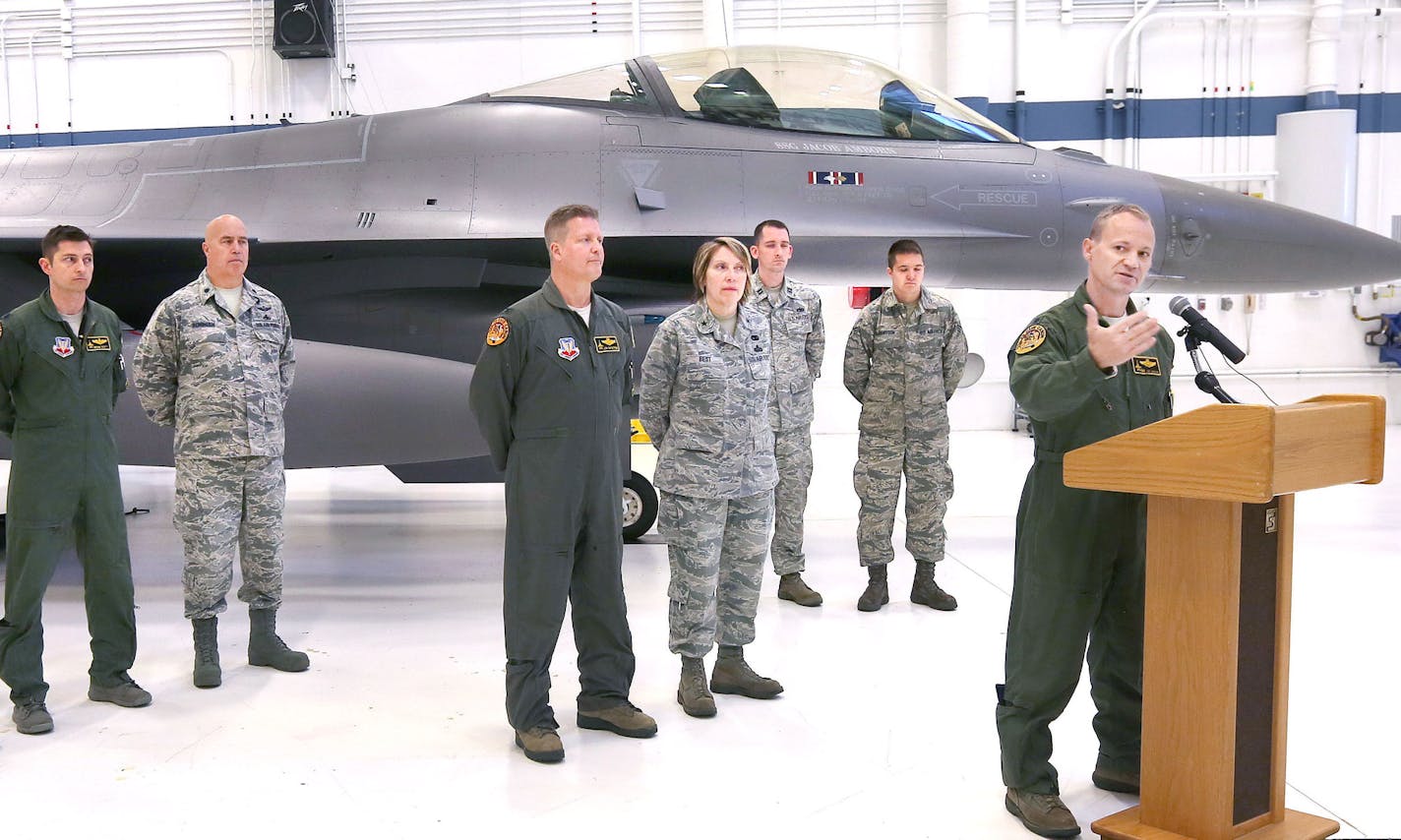 t4.1.16 Bob King -- king148th0402c3 - Lt. Col. Curt Grayson of the 148th Fighter Wing describes the unit's upcoming deployment to South Korea during a press conference at the Duluth Air National Guard base Friday morning. Other members of 148th listen as they stand alongside an F-16 Block 50 aircraft. Bob King / rking@duluthnews.com