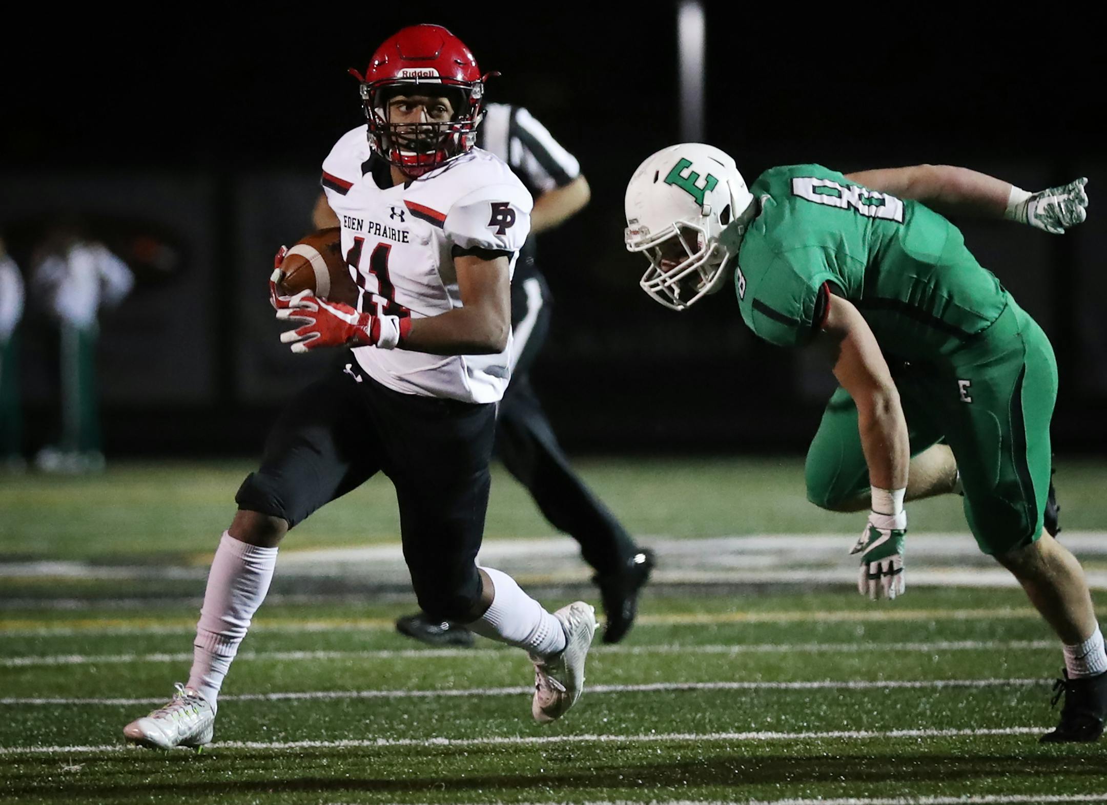 Eden Prairie High School wide receiver Daejon Wolfe (11) runs with the ball as Edina High School linebacker Nicholas Bloom (8) tries to tackle. ] LEILA NAVIDI ï leila.navidi@startribune.com BACKGROUND INFORMATION: Eden Prairie High School football at Edina High School on Wednesday, October 18, 2017.