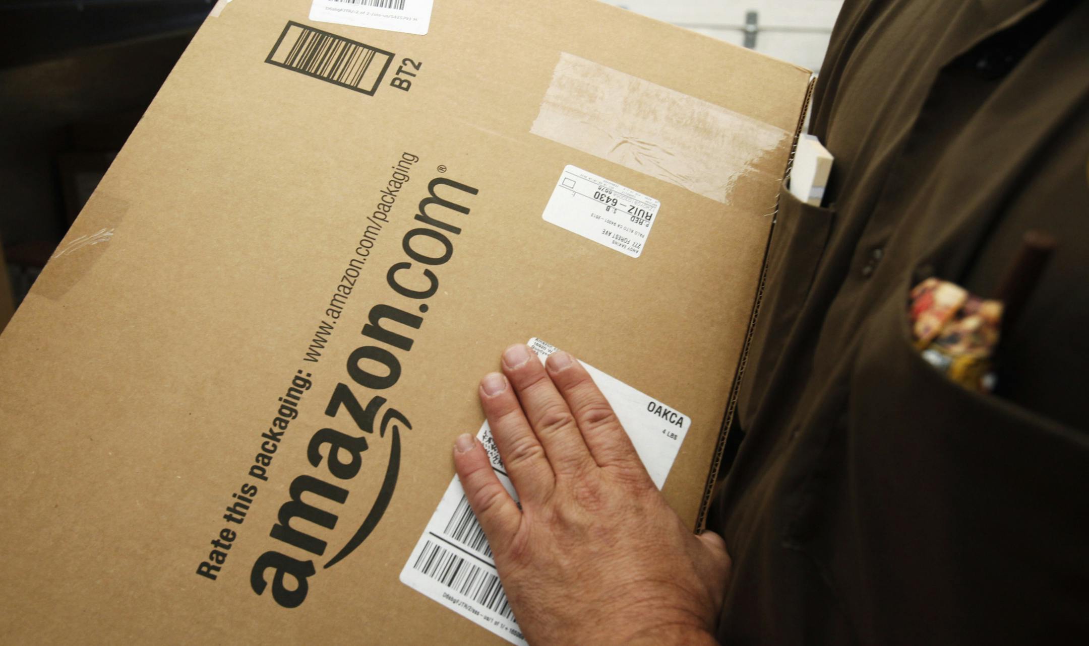An Amazon.com package is prepared for shipment by a United Parcel Service driver in Palo Alto, Calif.
