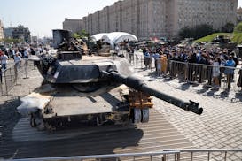 Representatives of the diplomatic corps look at U.S.-made M1 Abrams tank, and other U.S. military vehicles, hit and captured by Russian troops during 