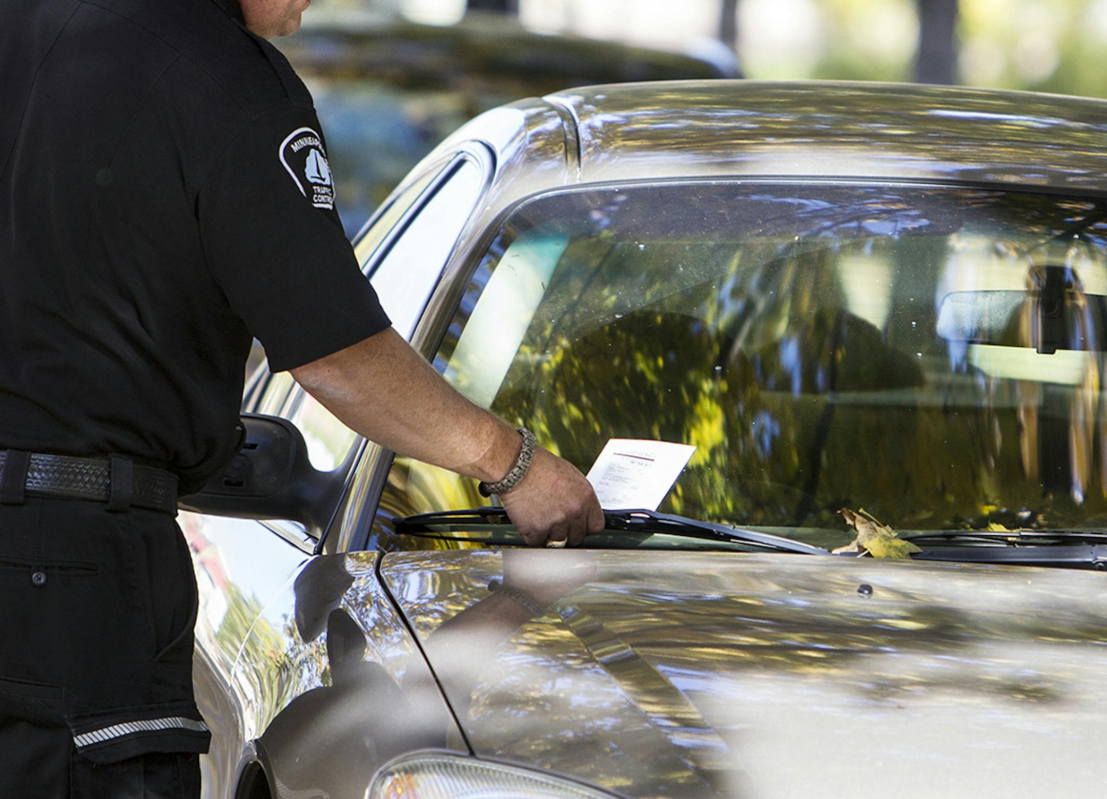 A Minneapolis Traffic Control officer who did not want to be named issued parking tickets during lunch hour on the 3100 block of Girard Avenue South in Minneapolis October 16, 2014. Multiple signs state that only cars with resident permits can park there, but the most ticketed location in the city is 3105 Girard Avenue South. (Courtney Perry/Special to the Star Tribune) ORG XMIT: MIN1410161415018057