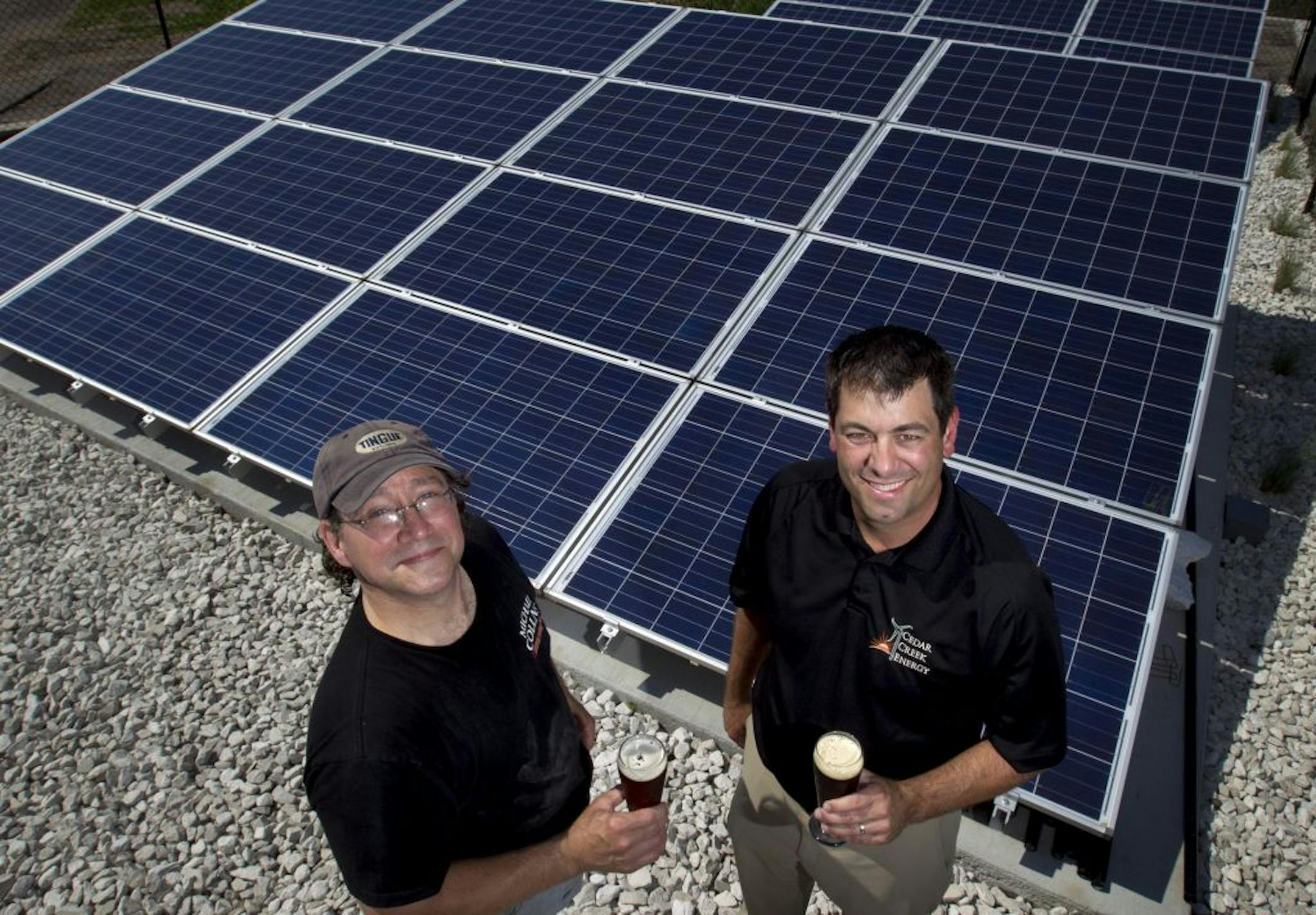 John Moore owner of Barley John's Brewpub and Rob Appelhof president of Cedar Creek Energy photographed in front of the solar array installed at Barley John's Brewpub in New Brighton, Minn.