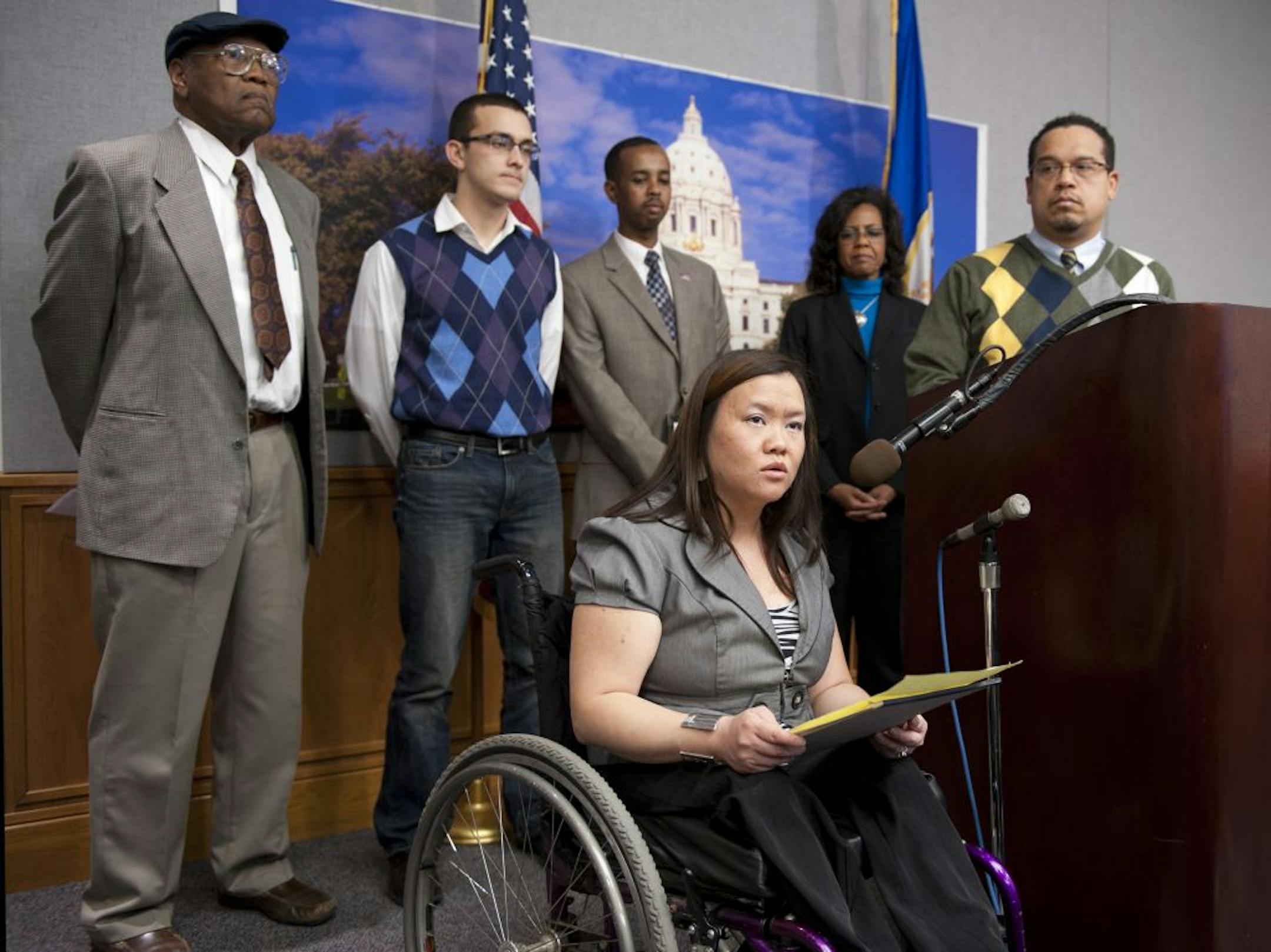 Mai Thor spoke at the State Capitol about how the proposed photo ID law would affect people with disabilities. Behind her, from left, were John Martin, Cory Baird, Dadik Warfa, Third District DFL candidate for Congress Sharon Sund and Rep. Keith Ellison, D-Minn.