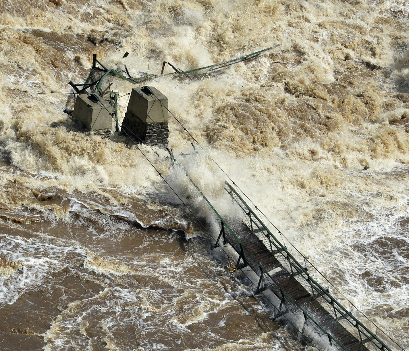 Water rages in the St.Louis River as it flows through Jay Cooke State Park, washing out major sections of Hwy. 210 and ripping out the swinging bridge in the park Thursday, June 21 2012 just south of Duluth, Minn. The floodwaters that swamped Duluth are rushing south and causing problems in Carlton and Pine counties. (AP Photo/The Star Tribune,Brian Peterson) MANDATORY CREDIT; ST. PAUL PIONEER PRESS OUT; MAGS OUT; TWIN CITIES TV OUT