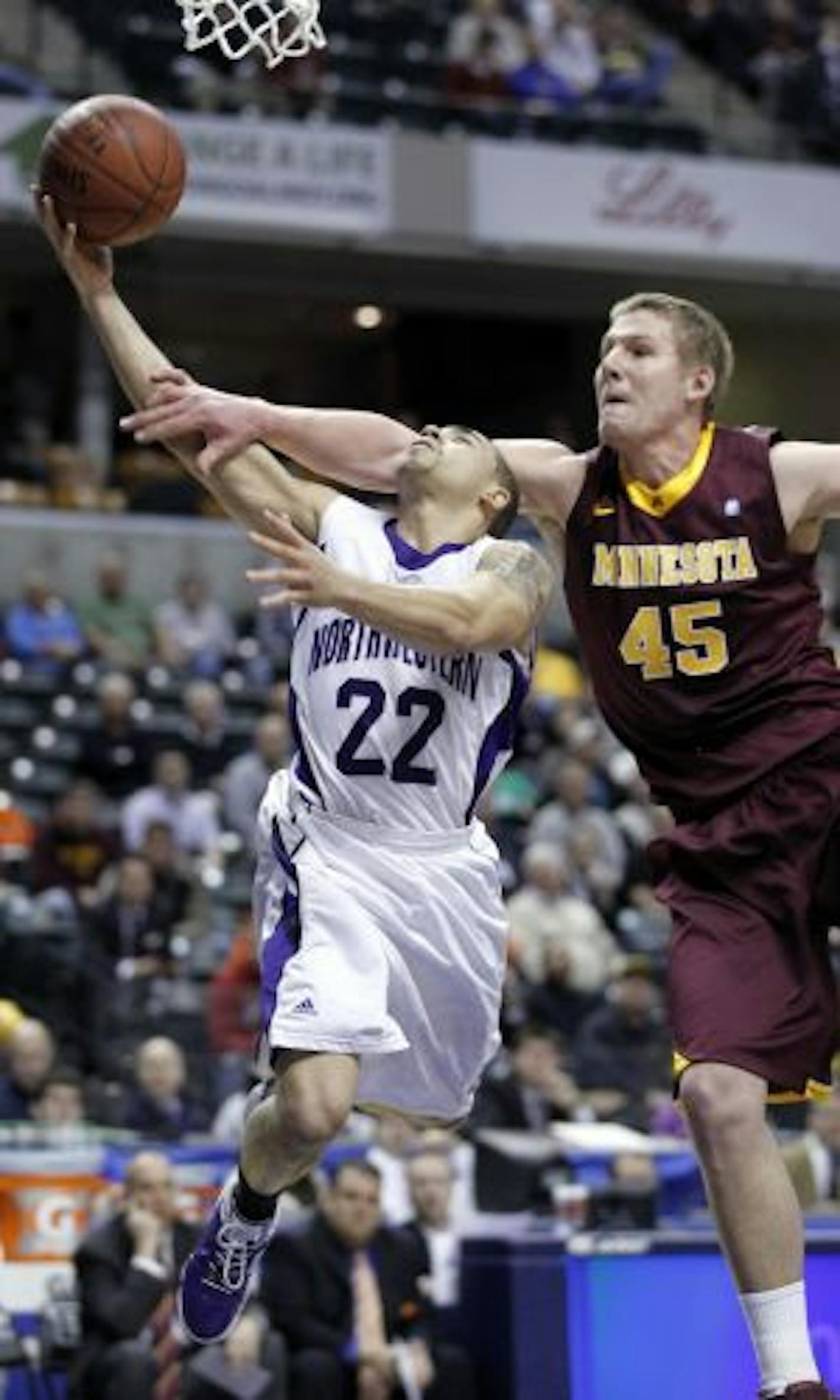 Northwestern guard Michael Thompson (22) was fouled by Gophers center Colton Iverson. Thompson scored 35 points, a Big Ten tournament record, in the Wildcats' 75-65 victory.