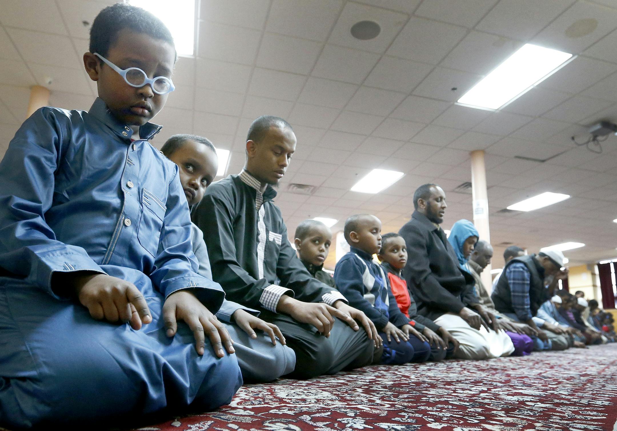 Mohamed Beare, 6, (left) prayed at the Abubakar As-Saddique in Minneapolis. Abubakar As-Saddique, the largest mosque in Minnesota hosted an open house on Wednesday. ] CARLOS GONZALEZ cgonzalez@startribune.com - April 6, 2016, Minneapolis, MN, Abuubakar mosque on 13th Av. So. in Minneapolis is hosting an open house for the neighborhood, Abubakar As-Saddique, the largest mosque in Minnesota, will open its doors to neighbors and non-Muslim community members for a tour and talk. Leader have held at
